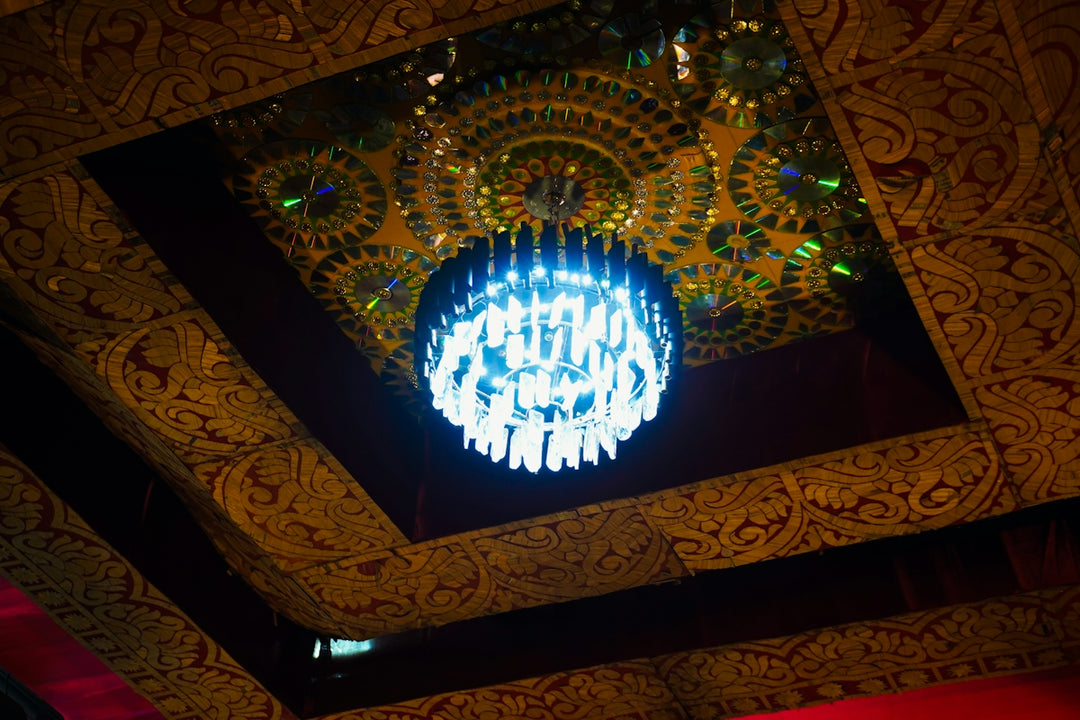 A decorative chandelier hangs from an ornate ceiling