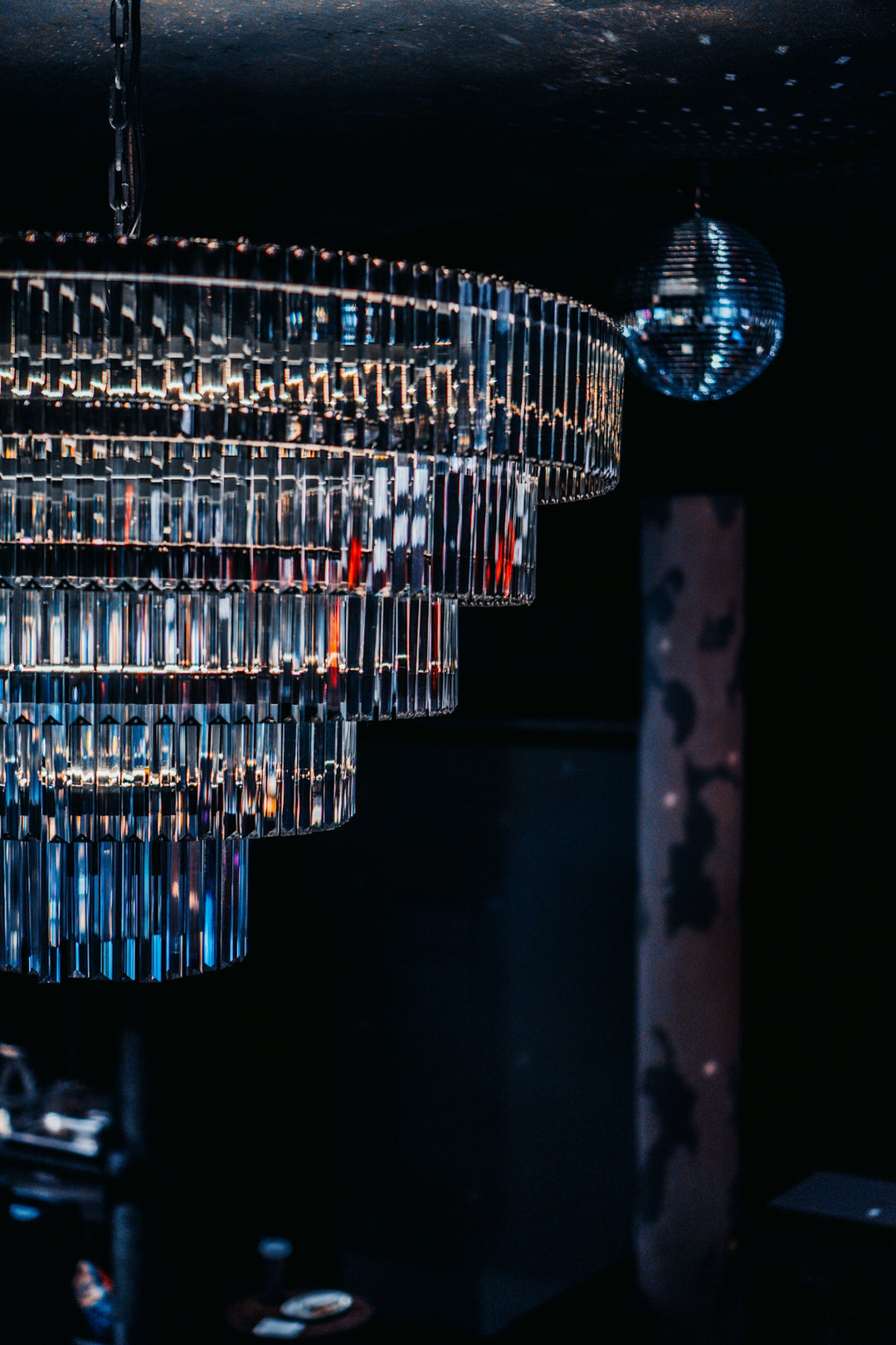 A multi-tiered crystal chandelier with a disco ball.