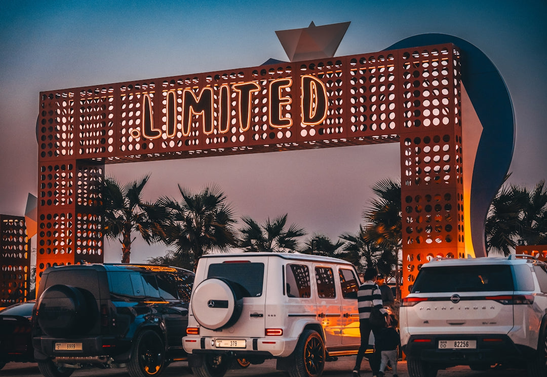 Cars parked under a large illuminated sign