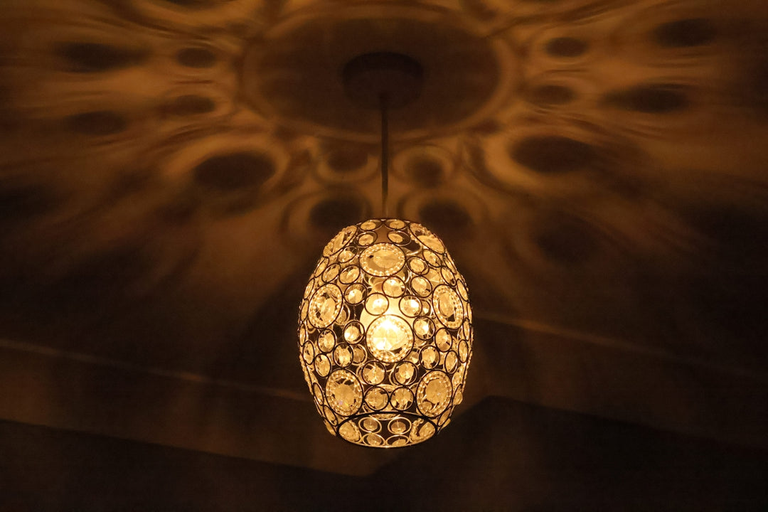 Ornate pendant light casting decorative shadows on ceiling