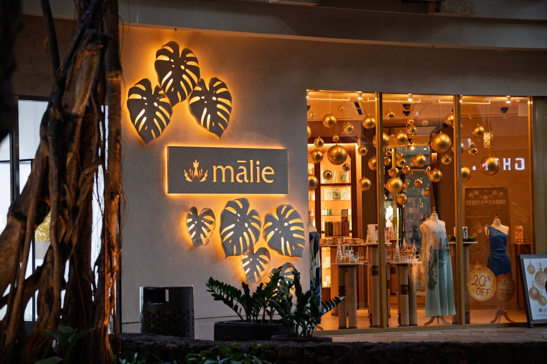 Storefront with illuminated monstera leaf decor and signage