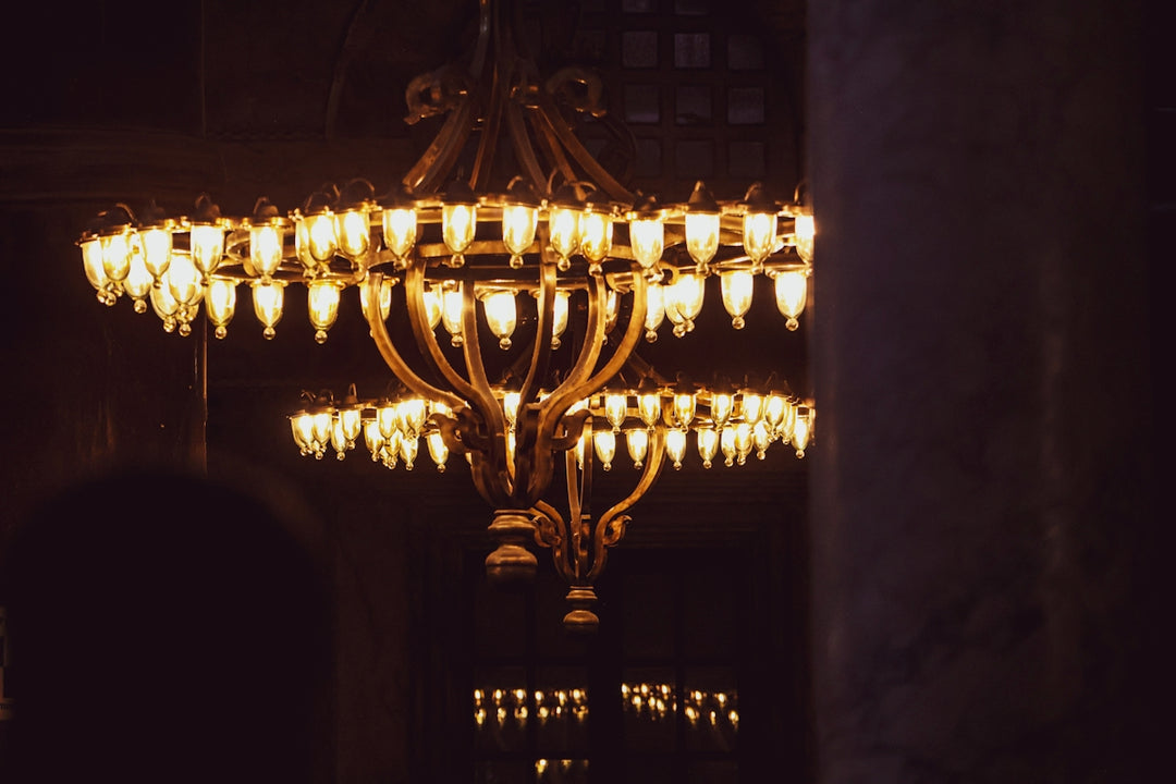 Ornate chandeliers illuminated in a dimly lit room