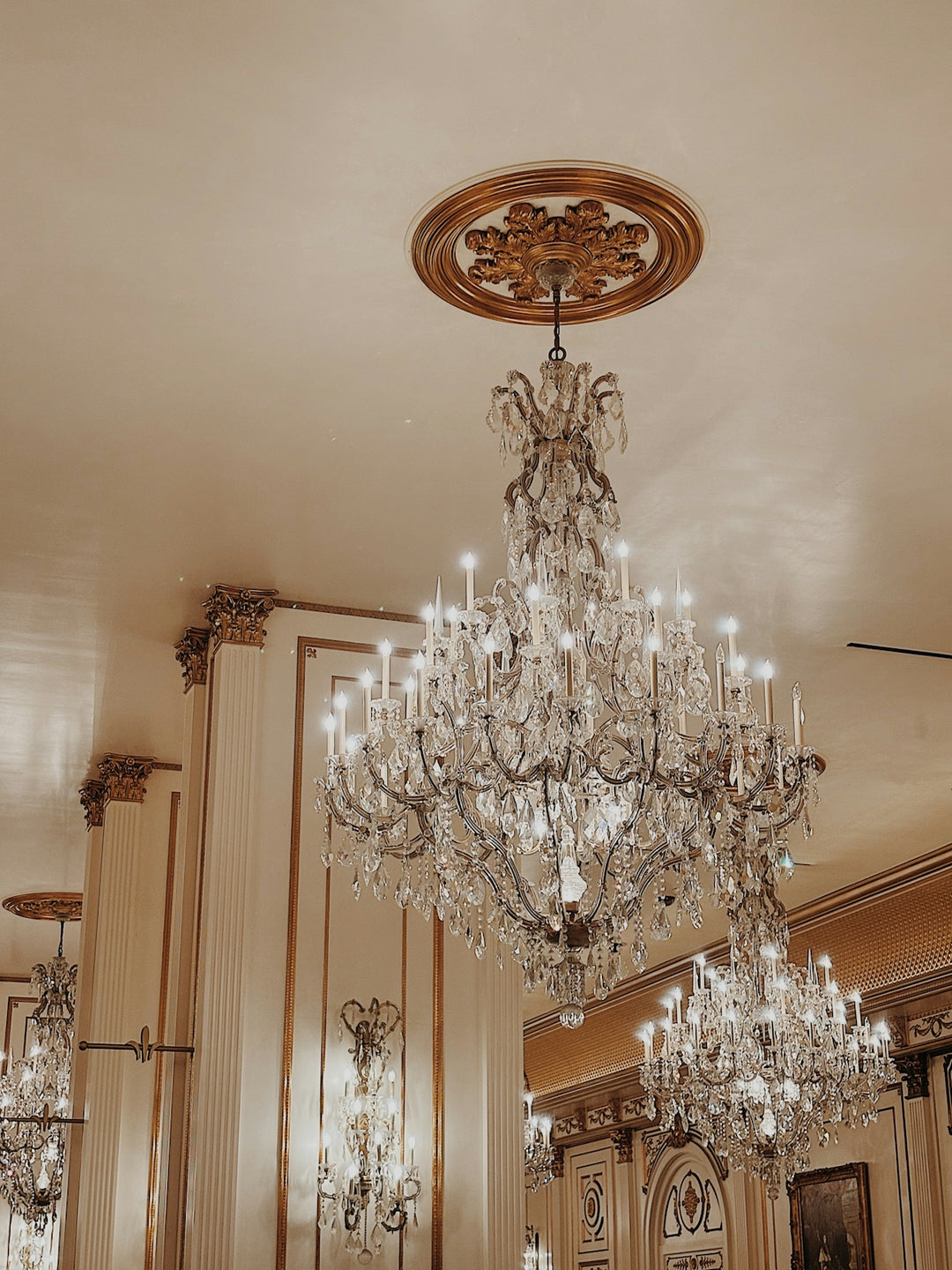 Elaborate crystal chandeliers hang from ornate ceilings.