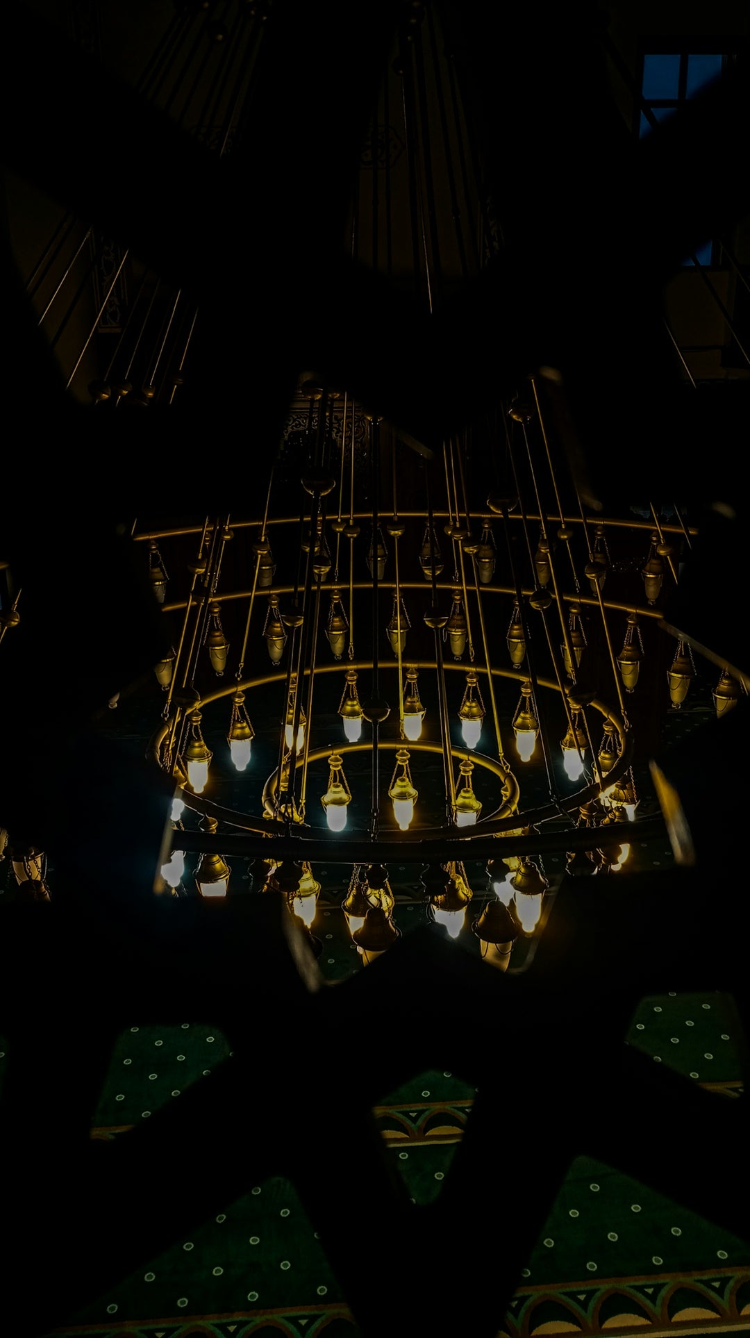 A large, ornate chandelier hangs in a dark room.