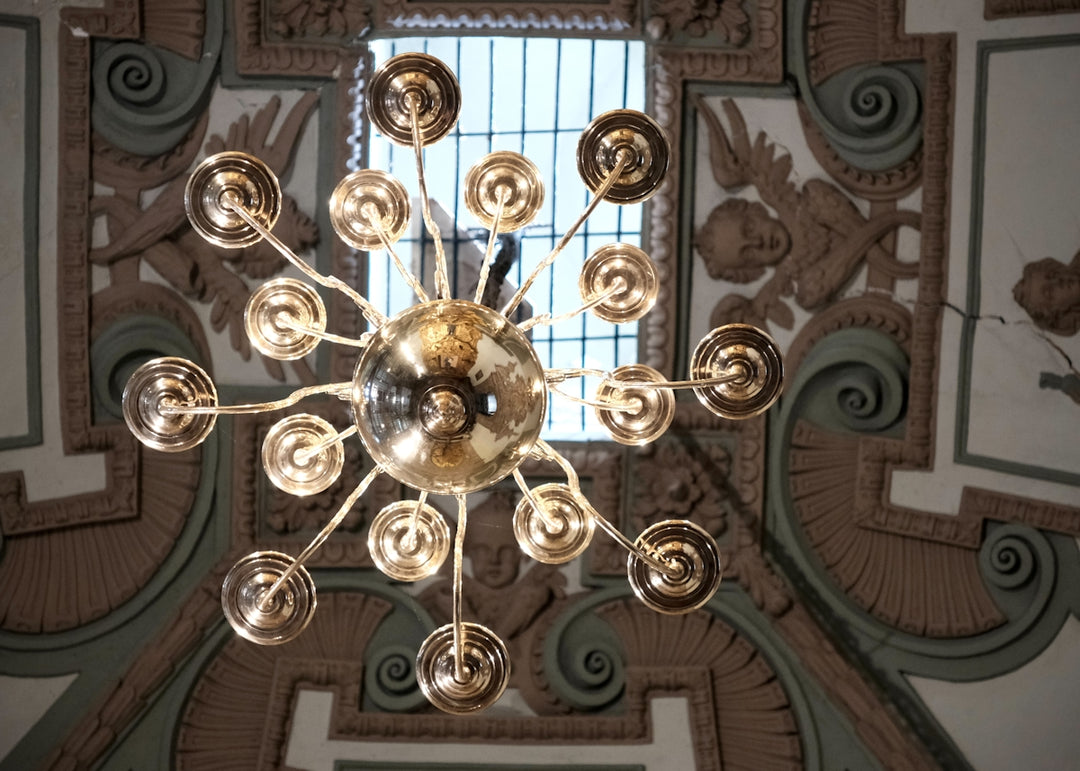 A modern chandelier with many lights hangs from ceiling.