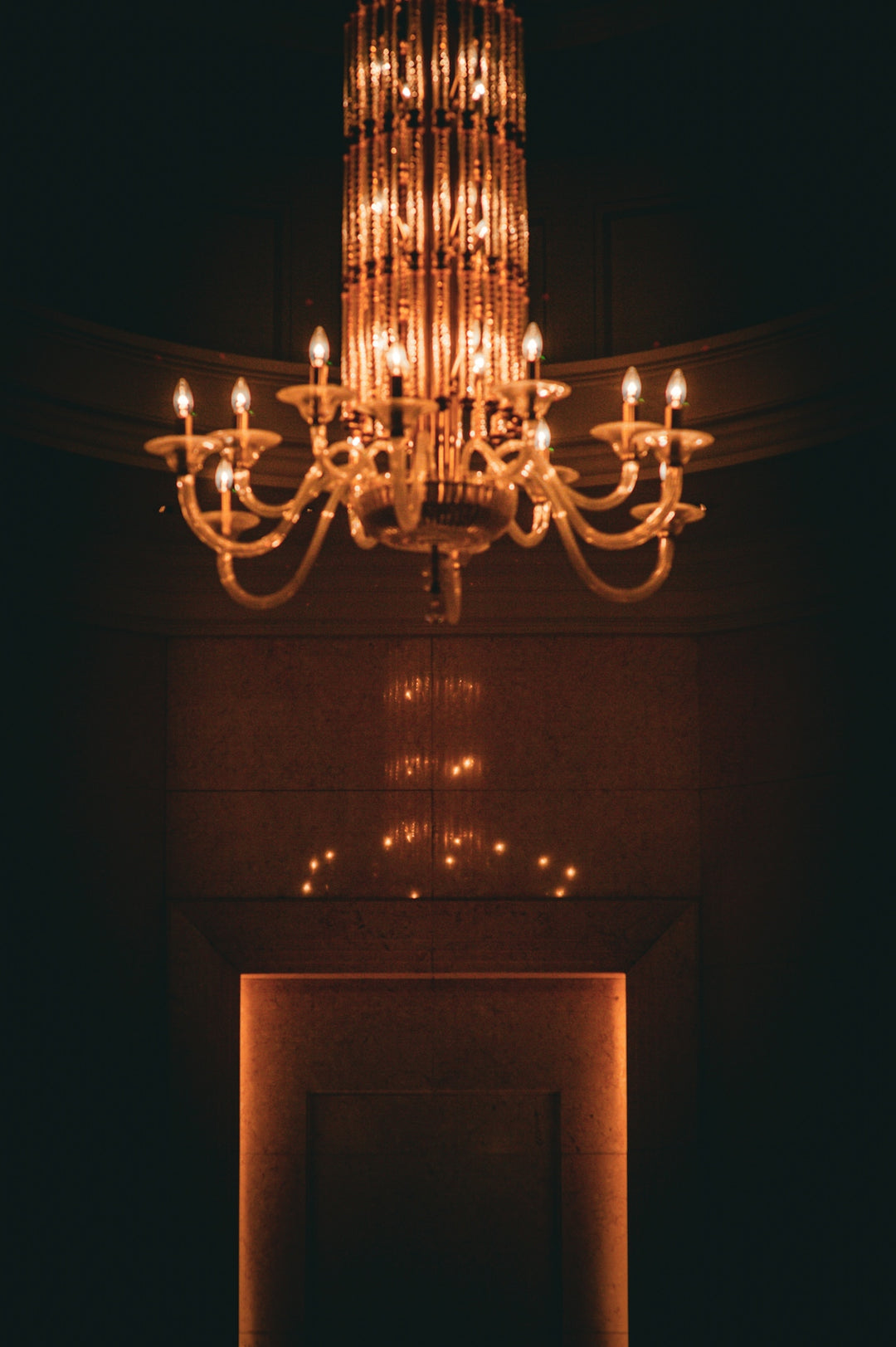 An ornate chandelier casts a warm glow downwards.