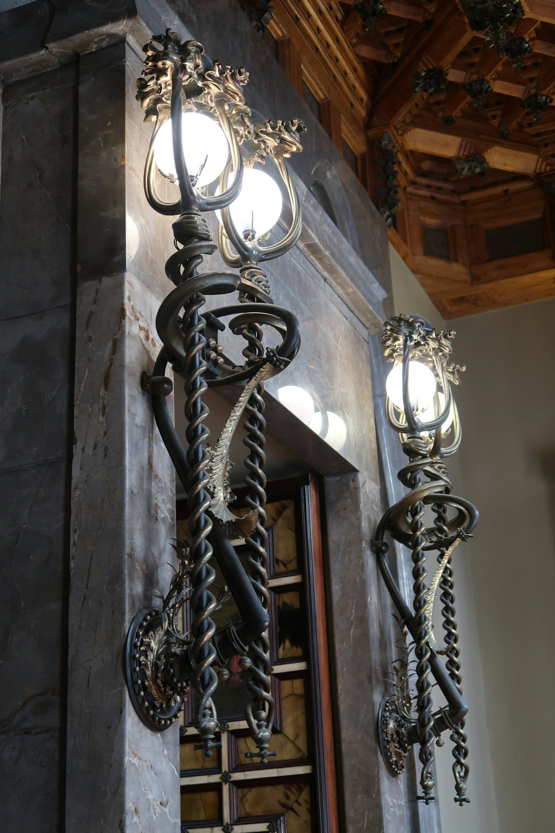 Ornate vintage wall sconces illuminate a decorative interior.