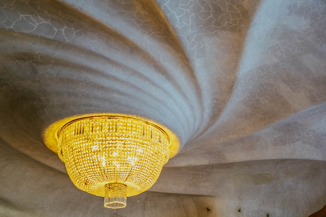 Ornate chandelier hangs from a swirling, textured ceiling.