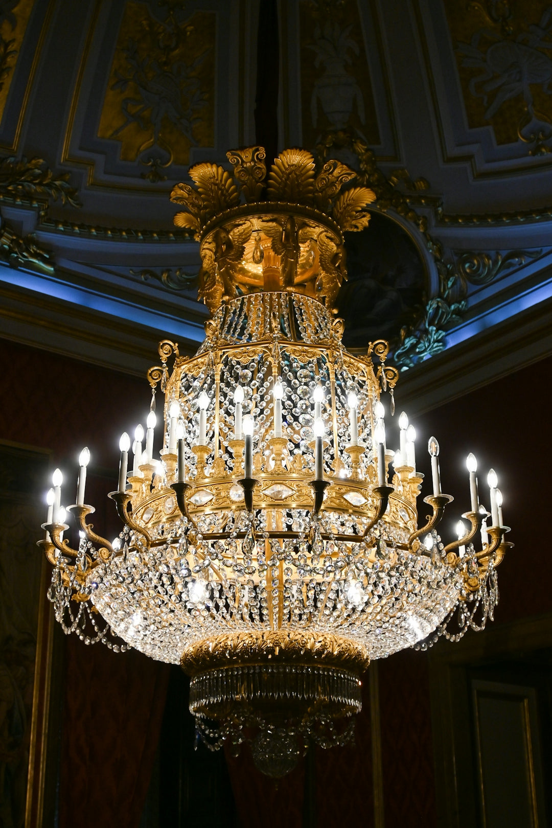 A magnificent gold and crystal chandelier with glowing lights.