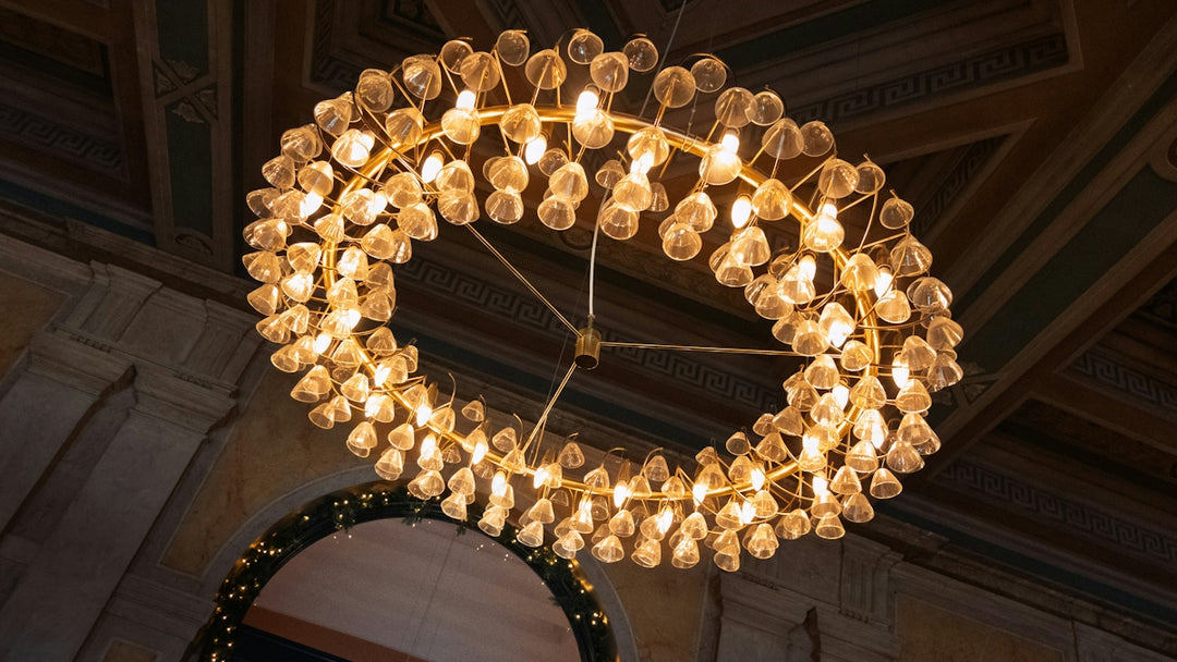 A large circular brass chandelier with many small glass shades in a room