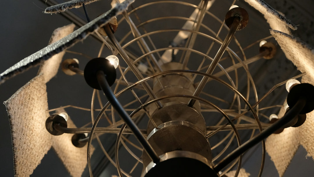 A low angle view of a tiered metal chandelier with small glowing bulbs