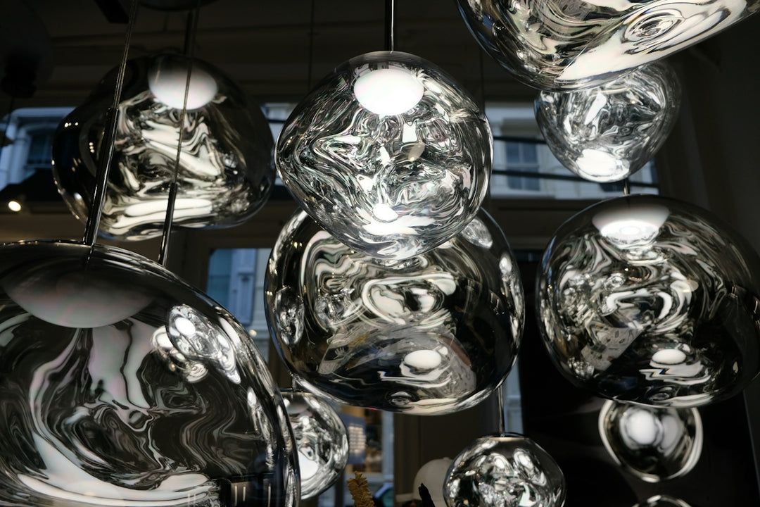 Group of reflective glass pendant lights with irregular shapes hanging in a room